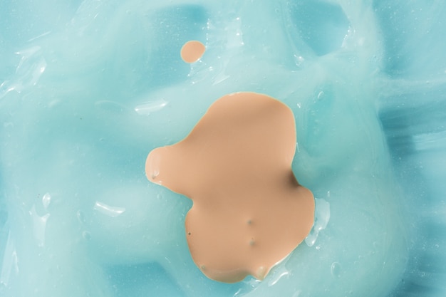 Flüssiger Foundation-Abstrich auf blauem cremefarbenem Hintergrund cremiges Hautpflege-Lotion-Mousse-Produkt