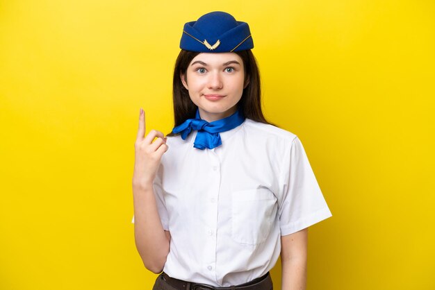 Flugbegleiterin Russische Frau isoliert auf gelbem Hintergrund, die mit dem Zeigefinger eine großartige Idee zeigt