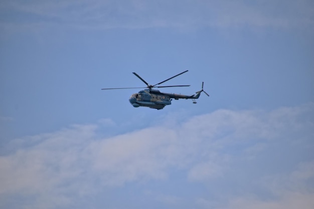Flugende Kampfhelikopter gegen einen blauen Himmel mit Wolken an einem sonnigen Tag