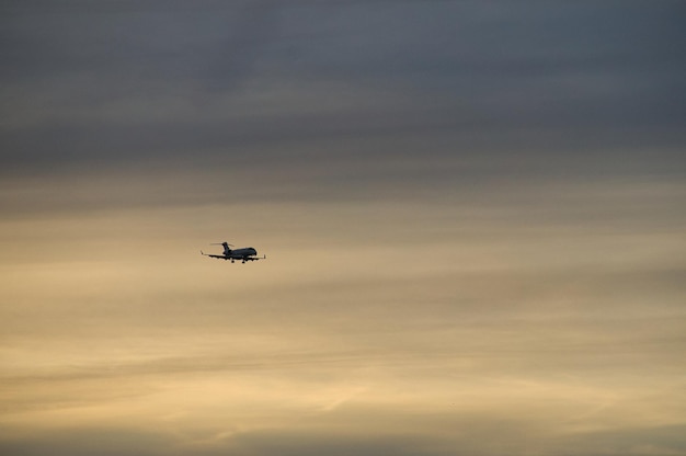 Flugzeug am Abendhimmel in leuchtendem Horizont