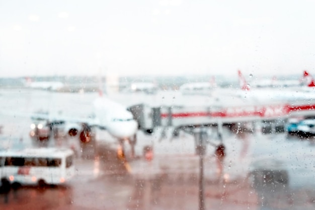 Flugzeug auf dem Flugplatz Blick durch das Fenster des Flughafenterminals Verschwommener regnerischer Hintergrund