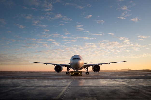Flugzeug auf der Start- und Landebahn gegen den Himmel bei Sonnenuntergang