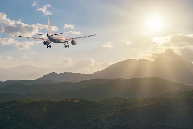 Flugzeug fliegt bei Sonnenuntergang über die Berge. Reisekonzept.