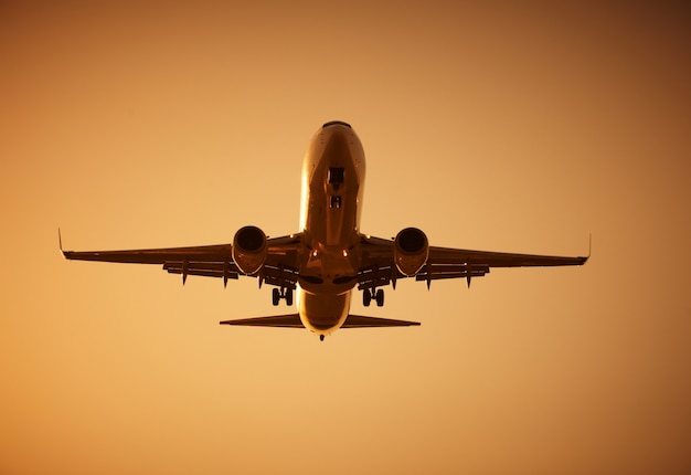 Flugzeug fliegt bei Sonnenuntergang