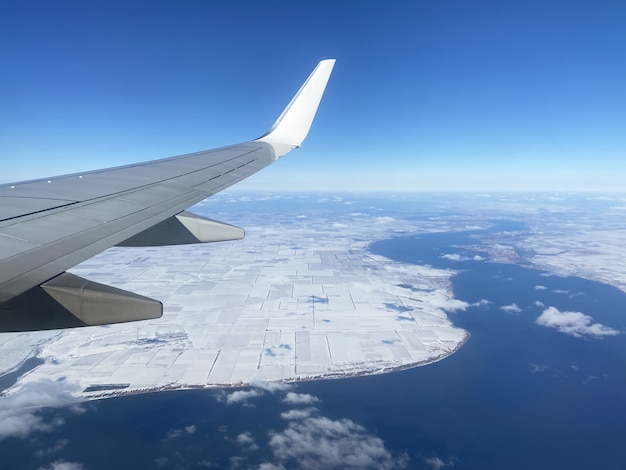 Flugzeug fliegt über schneebedeckten Boden