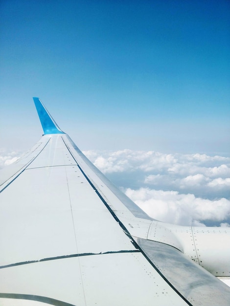 Flugzeug fliegt über Wolken gegen den blauen Himmel