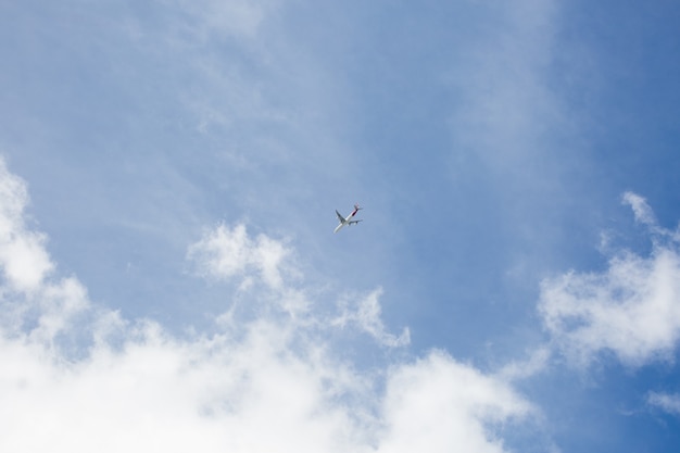 Foto flugzeug im flug gegen den blauen himmel.