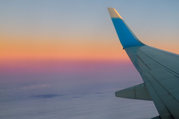 Flugzeug in den Himmel bei Sonnenaufgang Fliegen in der Wolken.