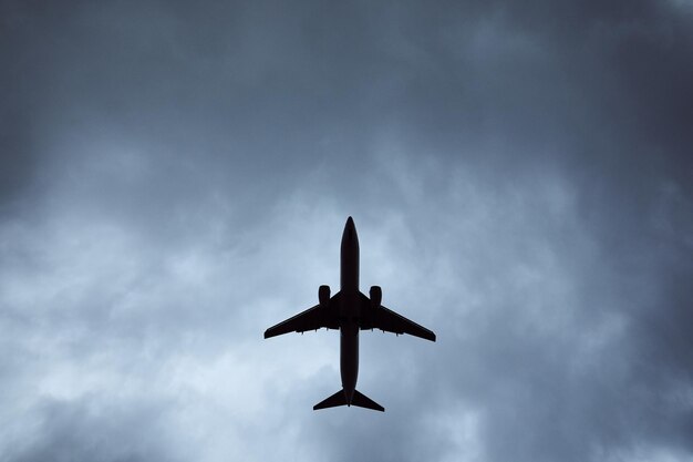 Flugzeug in dramatischen Wolken, niedriger Blickwinkel des Flugzeugs während der Landung im Windsturm