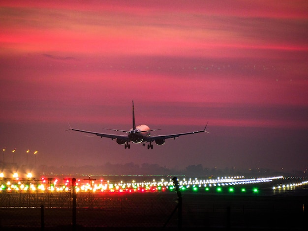 Foto flugzeug landet bei sonnenuntergang am flughafen von barcelona