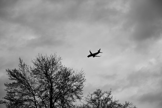 Flugzeug outined gegen einen grauen bewölkten Himmel