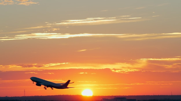 Flugzeug startet bei goldenem Sonnenuntergang