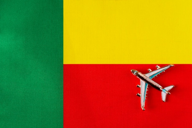 Flugzeug über der Flagge von Benin gleiche Reise