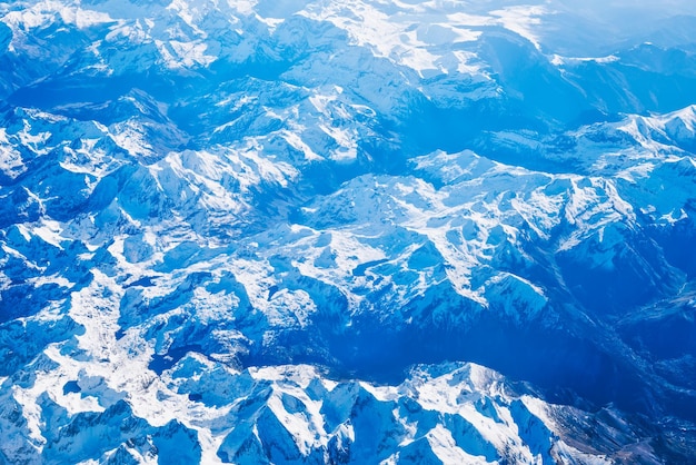 Flugzeugansicht der blauen Berge bedeckt mit weißem Schnee. Kann als Naturhintergrund verwendet werden