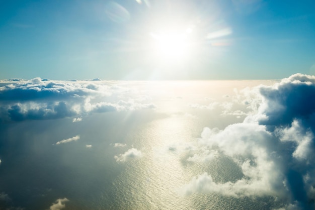 Flugzeugansicht der schönen Landschaft mit goldfarbenem Wolkenozean und hell leuchtender Sonne