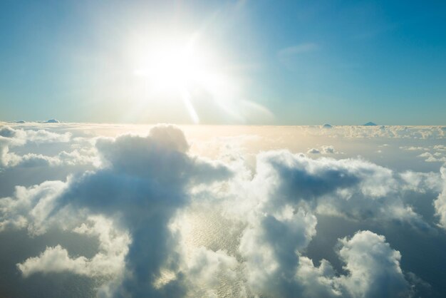 Flugzeugansicht der schönen Landschaft mit goldfarbenem Wolkenozean und hell leuchtender Sonne