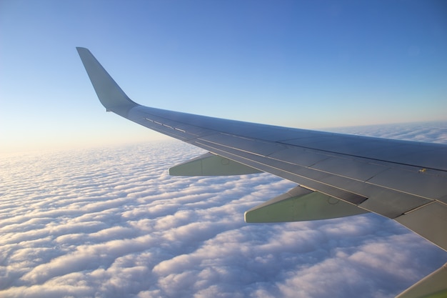 Flugzeugflügel am Himmel in großer Höhe über den Wolken