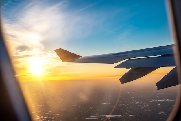 Flugzeugflügel bei Sonnenuntergang Reisen Flugreisen Fliegen und Reisen Blick vom Flugzeugfenster auf den Flügel bei Sonnenuntergang Blick über den Flugzeugflügel im Flug