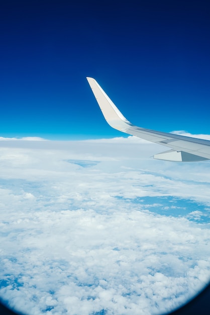 Flugzeugflügel mit blauem himmel und wolken