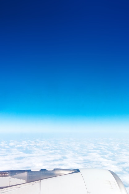 Flugzeugflügel mit blauem Himmel und Wolken