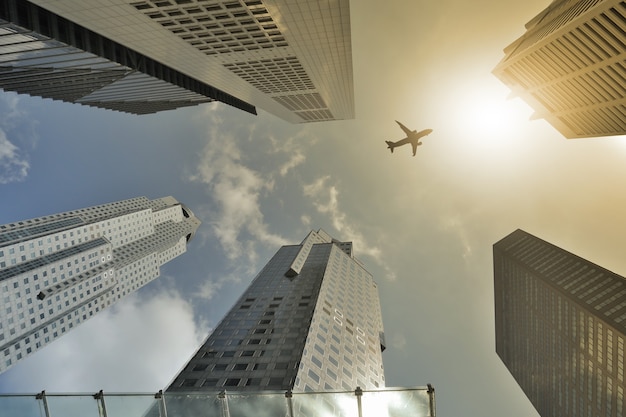 Foto flugzeugflug über modernes gebäude am nachmittag.