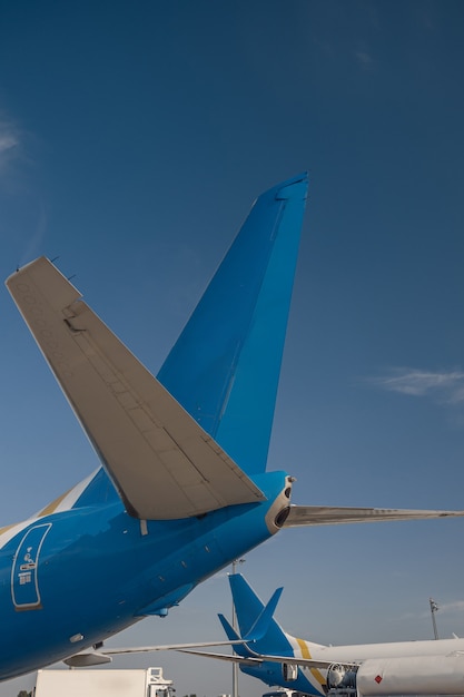 Flugzeugheck internationaler Fluggesellschaften im Flughafen mit blauem Himmel im Hintergrund. Flugzeug, Transportkonzept