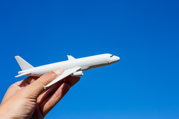 Flugzeugmodell in der Hand am sonnigen Himmel Konzepte des Reisetransports Transport träumen von Ferien