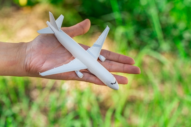 Flugzeugmodell in der Hand auf sonnigem Himmel. Konzepte des Reisens, Transport