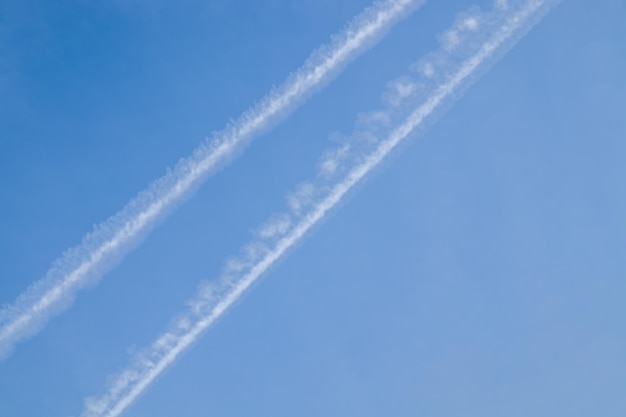 Flugzeugspuren mit bewölktem blauem Himmel