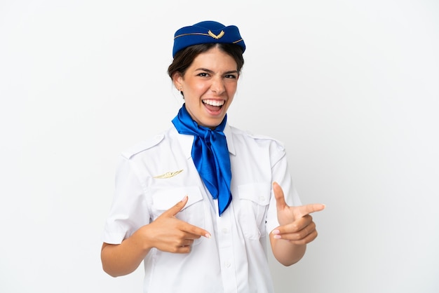Flugzeugstewardess kaukasische Frau isoliert auf weißem Hintergrund, die nach vorne zeigt und lächelt