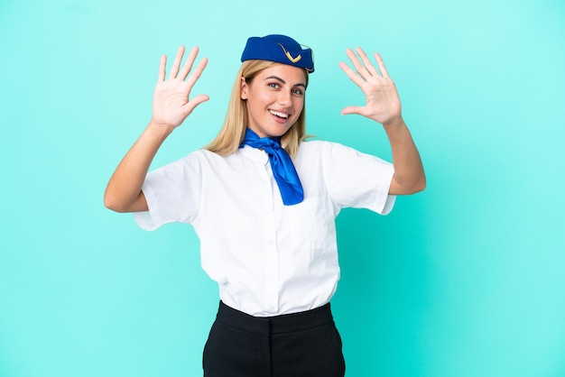 Flugzeugstewardess uruguayische Frau isoliert auf blauem Hintergrund, die zehn mit den Fingern zählt