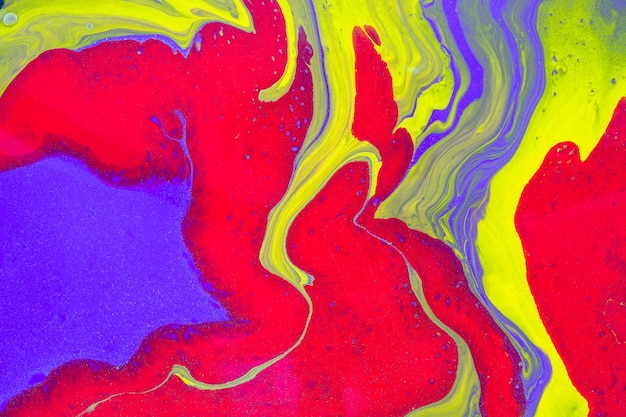 El flujo libre de colores rojo, púrpura y amarillo crea un efecto de mármol. Fondo o textura ondulada abstracta de arte fluido acrílico.