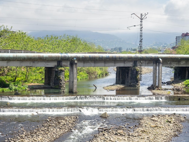 Flujo rápido del río Vista desde el puente hasta el agua Umbrales en el agua Rápidos artificiales en el río Tecnología en el agua