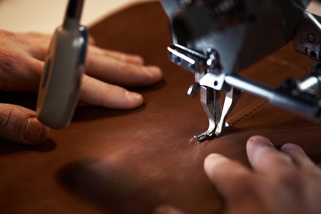 Flujo de trabajo del trabajador del cuero un curtidor o pelador cosía el cuero en una máquina de coser especial en la que un trabajador cosía