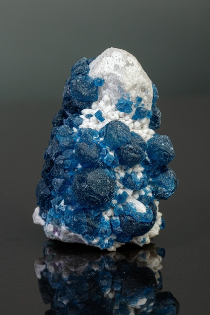 Fluorita de piedra mineral macro sobre cuarzo sobre un fondo gris