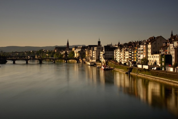 Foto fluss durch beleuchtete gebäude gegen den himmel in der dämmerung