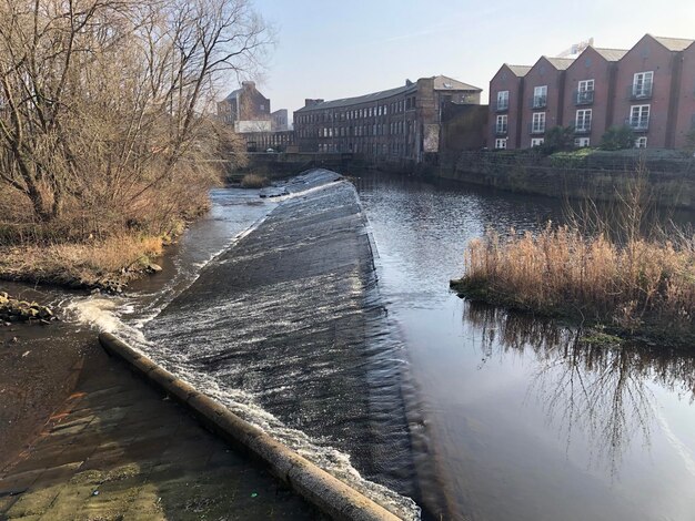 Foto fluss fließt inmitten von gebäuden gegen den himmel