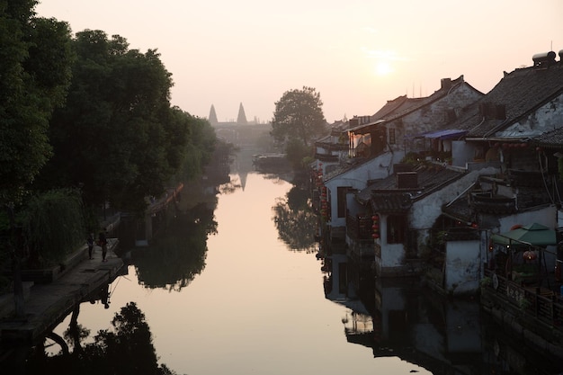 Foto fluss inmitten von gebäuden gegen den himmel bei sonnenuntergang