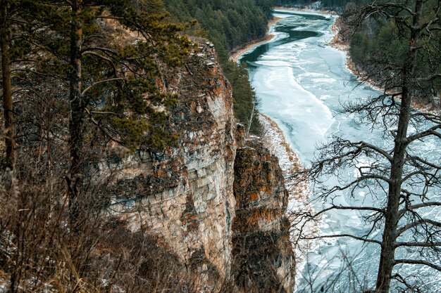 Fluss- und Felsküste in der Taiga im Winter