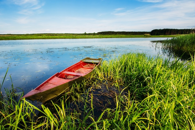 Flusslandschaft mit einem roten Boot