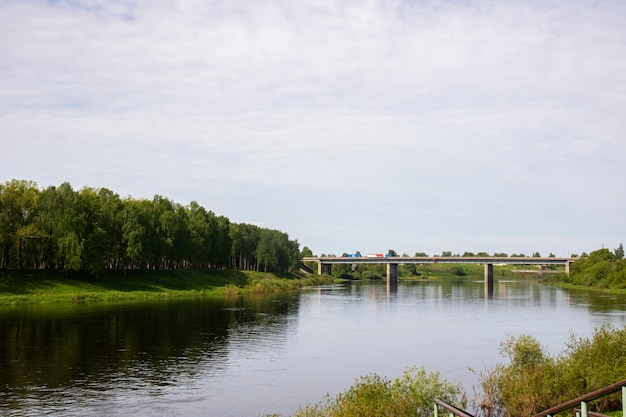 Flussufer mit Bäumen und Brücke für Autos