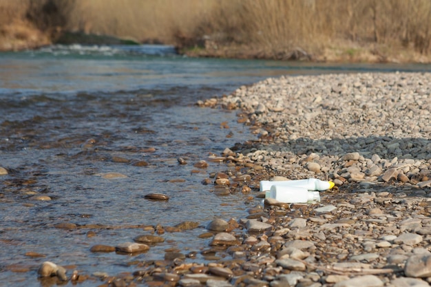 Flussverschmutzung in Ufernähe Müll in der Nähe des Flusses Lebensmittelabfälle aus Kunststoff tragen zur Verschmutzung bei