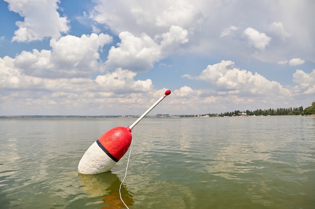 Flutuador grande flutua na superfície calma do lago aguardando mordida