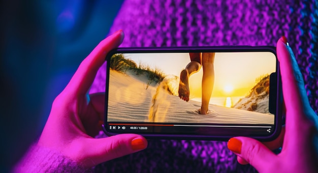 Fluxo de filme online com smartphone Mulher assistindo filme no celular com serviço de player de vídeo imaginário