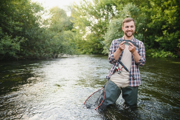 Flyfisherman sosteniendo truchas fuera del agua