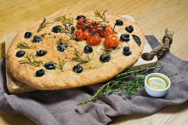 Focaccia caseiro em uma tabela de madeira.