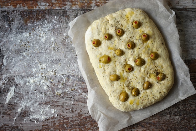 Focaccia italiana con aceitunas antes de hornear.