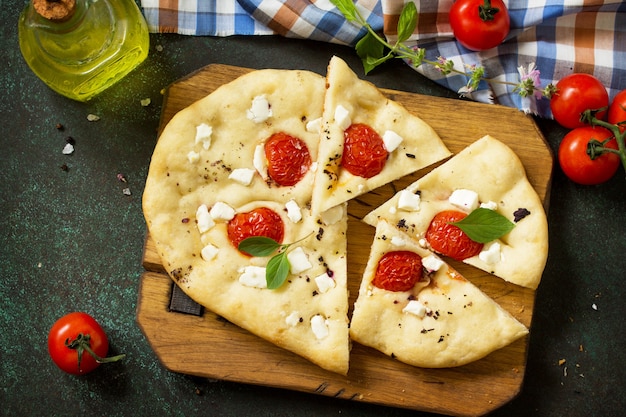 Focaccia italiana tradicional com tomate alecrim e queijo feta Vista de cima plano de fundo