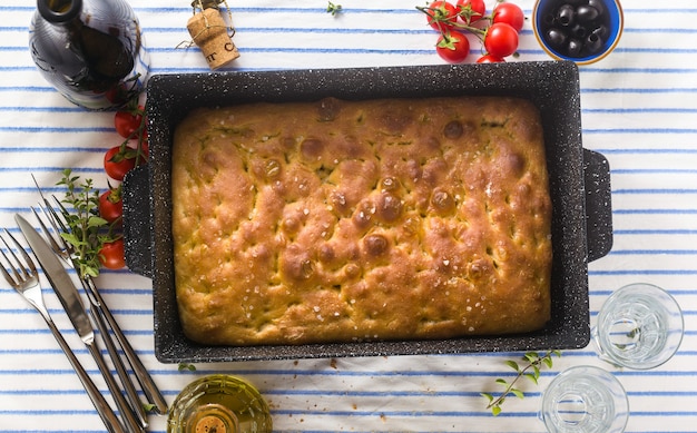 Focaccia italiana y verduras a la parrilla sobre una mesa con vino tinto y hierbas aromáticas. menú de verano