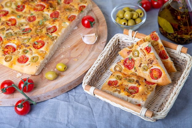 Focaccia mit Tomaten und Oliven. Traditionelles italienisches Brot. Hausgemachtes Backen.